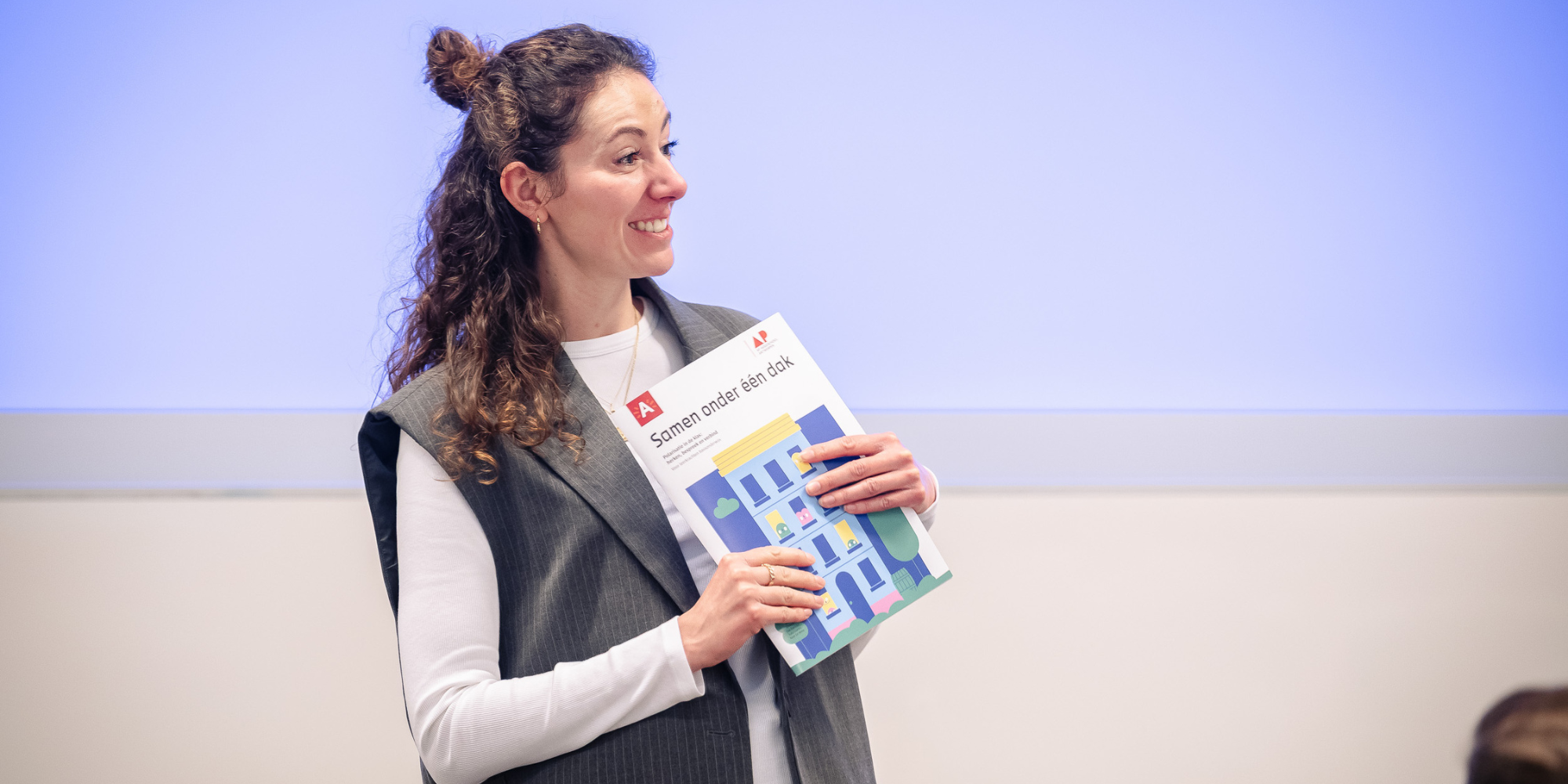 Een vrouw houdt de toolkit Samen onder één dak vast